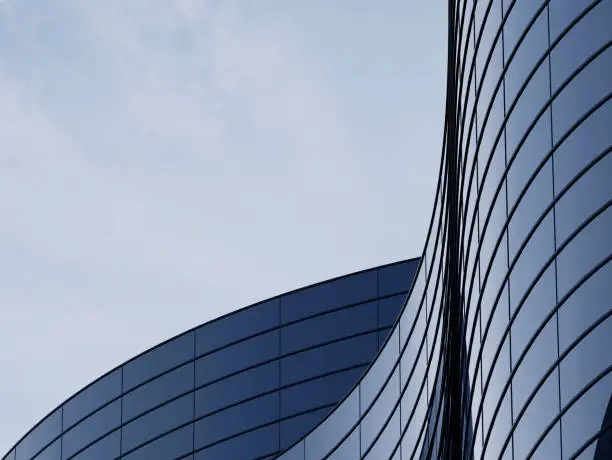 Photo of 3D stimulate of high rise curve glass building and dark steel window system on blue clear sky background,Business concept of future architecture,lookup to the angle of the corner building.3d rendering