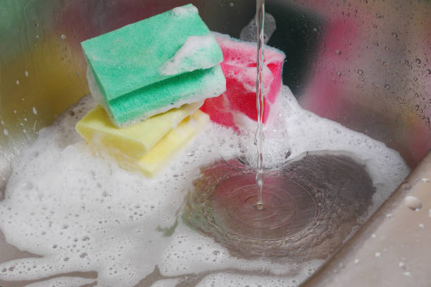 istock three colorful sponges in kitchen sink under running water 991229606