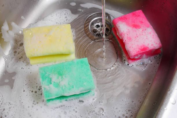 istock three colorful sponges in kitchen sink under running water 991229994