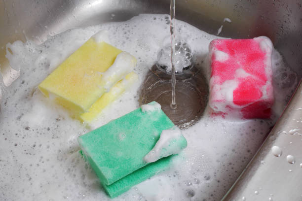istock three colorful sponges in kitchen sink under running water 991231372