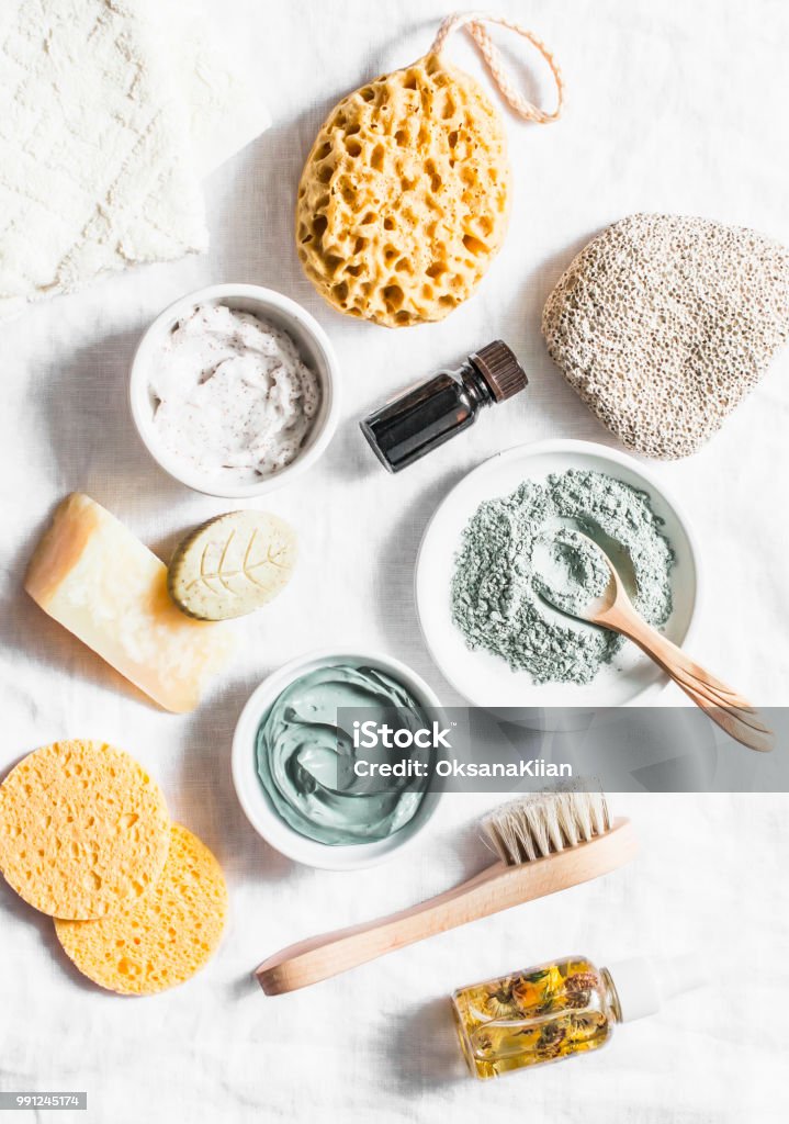 Spa accessories - nut scrub, sponge, facial brush, natural soap, clay face mask, pumice stone, essential oil on a light background, top view. Healthy lifestyle concept. Beauty, skin care. flat lay Beauty Stock Photo