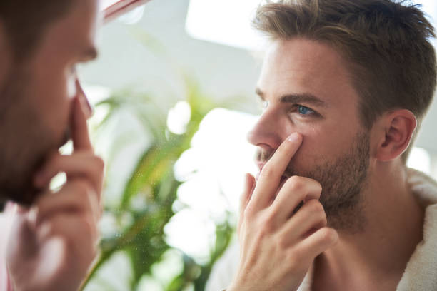 istock Attractive male checking on wrinkles in bathroom 991245336