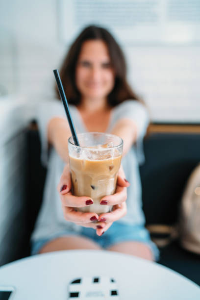 istock Young Woman Drinking Ice Coffee 991248778