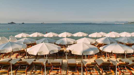 Rows of empty beach lounges and sun umbrellas on a beach in Juan les Pins, France.