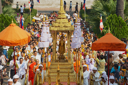 Luang Prabang, Laos - April 16, 2012: Unidentified people take part in the religious procession after Pra Bang (the main Buddah of Luang Prabang) being taken out of the Royal palace to the Wat Mai Buddhist temple during Phi Mai (Lao New Year) celebrations in Luang Prabang, Laos.