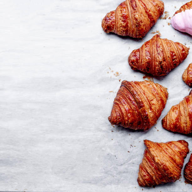 istock Croissants.  Fresh croissants on a grey background with copyspace for text. Flat lay. French bakery concept.