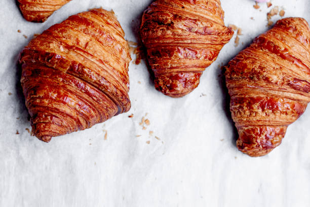 istock Croissants.  Fresh baked croissants on a bright kitchen table with copy space for text. Flat lay. French bakery concept.