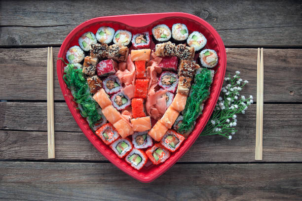 istock Sushi on a old wooden table background with a heart shaped decor 991299872