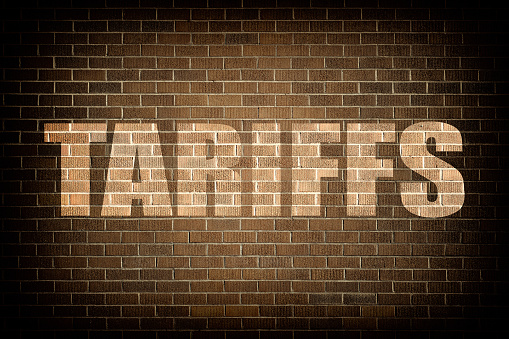 Tariffs brick wall text concept.