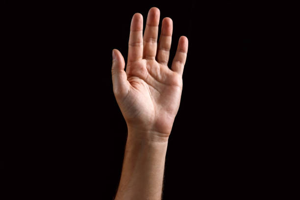 istock Male palm raised up, isolated on a dark background. Isolate 991348866