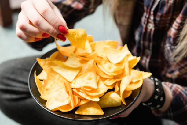 istock junk fast food nutrition chips woman eating 991353710