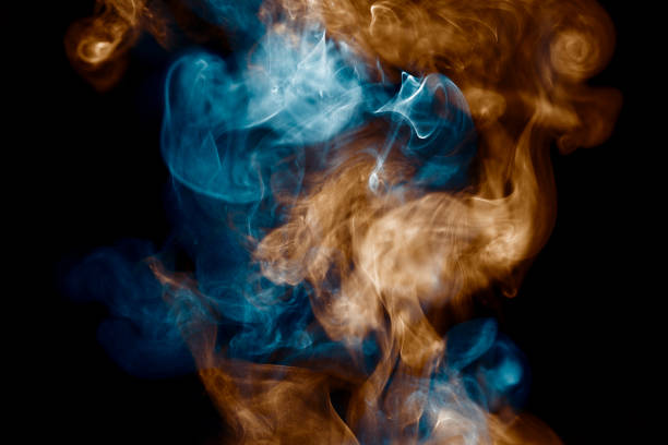 istock Orange and Teal Coloured Steam on Black Background 991363590