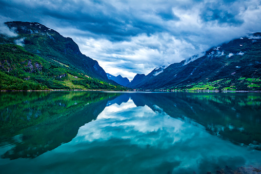 panoramic view of Norwegian mountain lake and mountains in the clouds