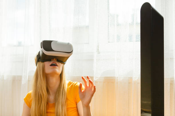 istock Girl wearing virtual reality goggles at home 991367900