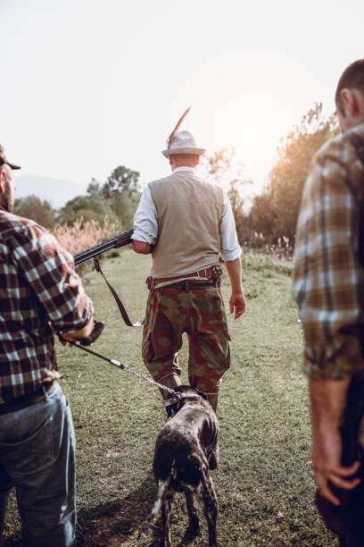 istock Group Of Male Hunters Walking With Hound 991369800