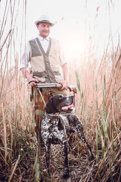 istock Hunter Walking Through Swamp With Dog Looking For Prey 991372238