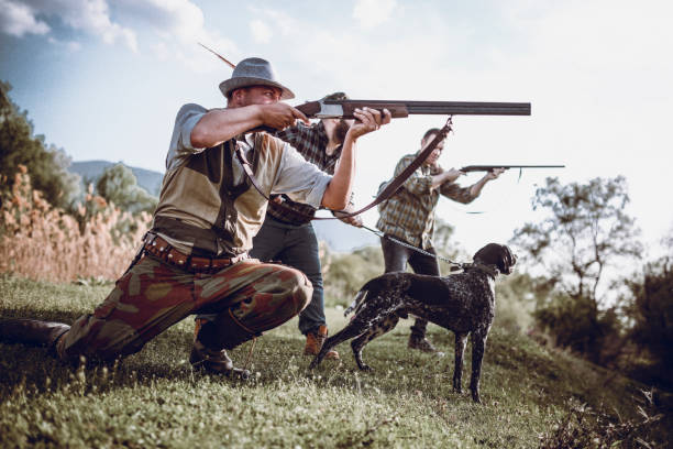 istock Hunters In Action Preparing To Shoot And Dog Pulling Chain To Help Them 991372754