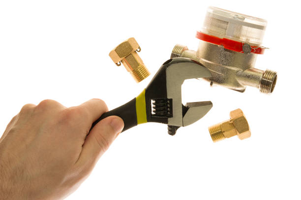 istock Wrench in hand, water meters, couplings on white background 991372942