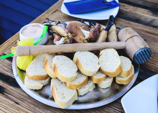 plate with boiled legs and claws of brown crab with bread and dip on wooden table plate with boiled legs and claws of brown crab with bread and dip on rustic wooden table helgoland stock pictures, royalty-free photos & images