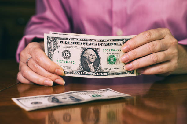 istock Woman counts dollar bills, banknotes in female hands. 991373774