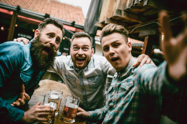 istock Happy Friends Making Faces While Drinking Beer In Bar 991373978