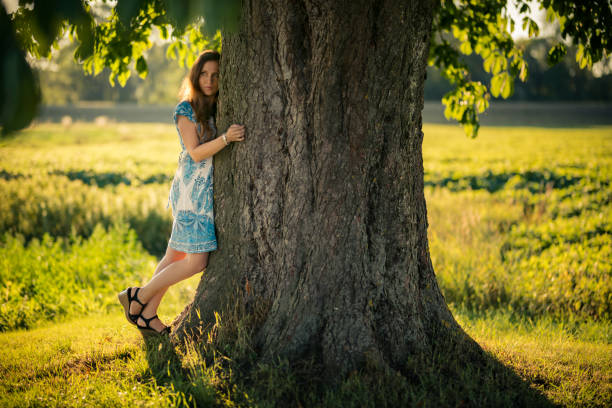 istock women in the sunny evening sky hug a tree 991376776