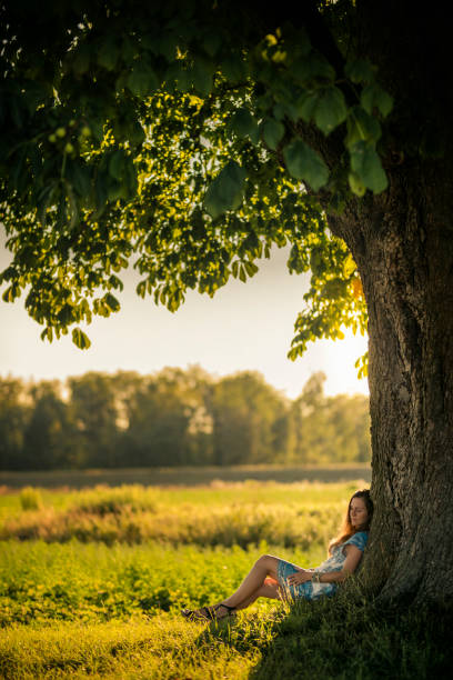 istock Beautiful women relaxing under a chestnut-tree 991379008