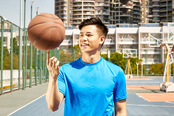 young asian adult playing with a basket ball
