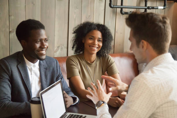 istock Caucasian architect consulting black clients out in coffee shop 991406816