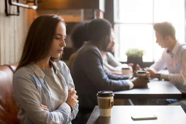 Upset girl ghosted by boyfriend, waiting for him alone in coffeeshop, frustrated female rejected by admirer or lover, wasting time for cancelled date, sad outcast jealous of happy friends in cafe,