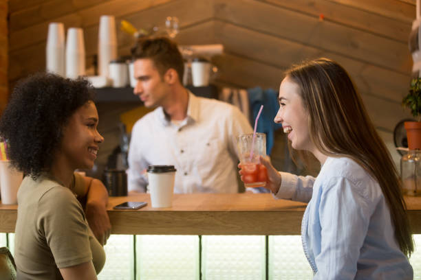 istock Multiracial girlfriends laughing, enjoying drinks at bar counter in cafe 991406918