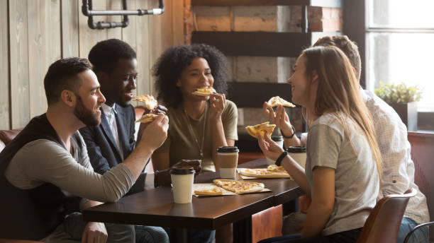 istock Smiling multiracial colleagues enjoying lunch spending work break in cafe 991406938