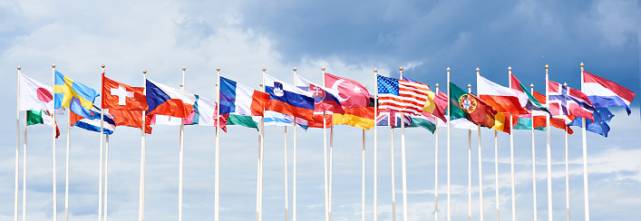 Colorful flags garland of different countries before blue sky
