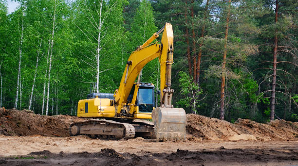 yellow excavator with a crawler on a caterpillar track, works on the construction of a highway yellow excavator with a crawler on a caterpillar track, works on the construction of a highway Earthmoving stock pictures, royalty-free photos & images