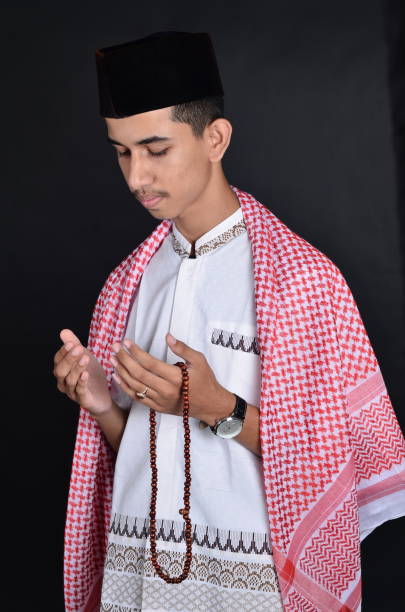 istock Young asian muslim man praying with prayer beads 991419408