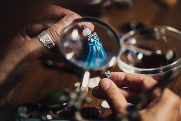 Woman making handmade jewelry, busy hands, close up.