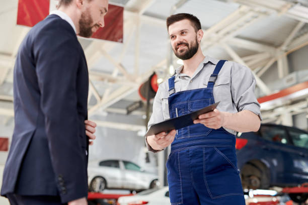 istock Smiling Mechanic Giving Contract to Client 991427864