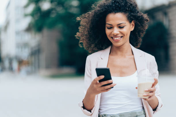 istock Happy woman walking and texting 991428908