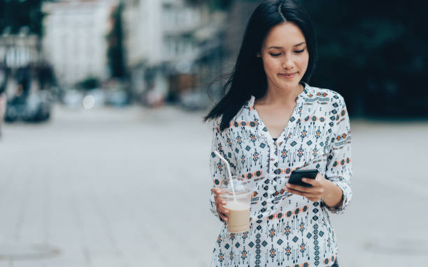 istock Happy woman walking and texting 991428936