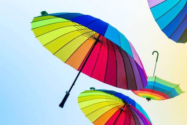 istock Rainbow colored umbrellas flying in the sky 991434648