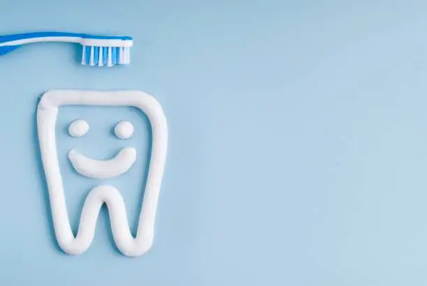 Toothbrush and tooth paste on a blue background