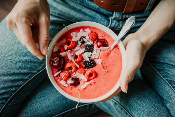 istock Woman eating healthy smoothie bowl 991437982