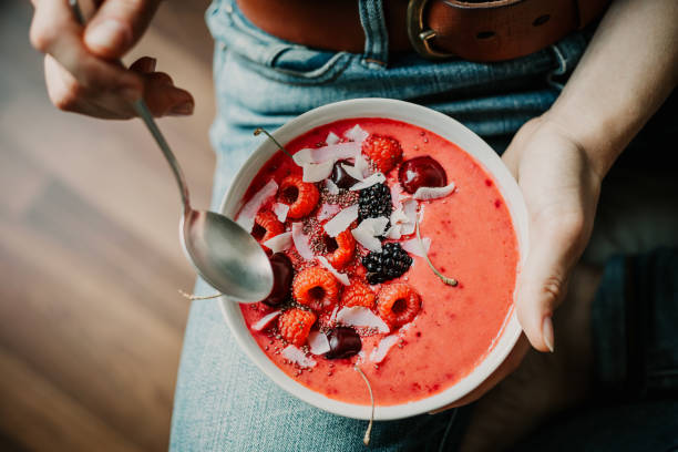 istock Woman eating healthy smoothie bowl 991438114
