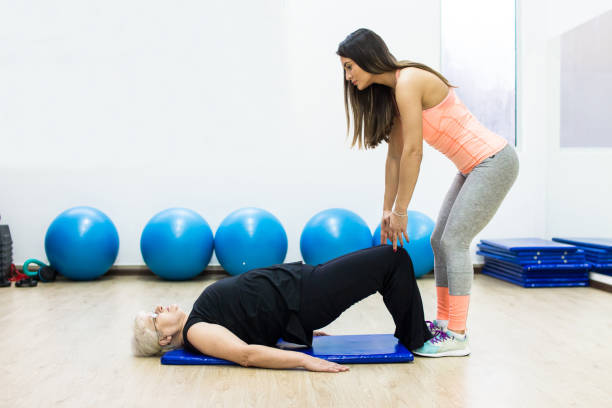 istock senior woman with a personal trainer 991439604