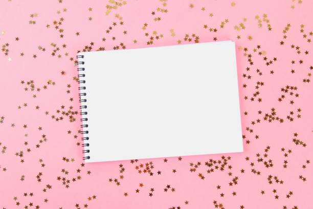 istock An empty pad on a pastel background surrounded by shiny decorative stars and balls. 991440160