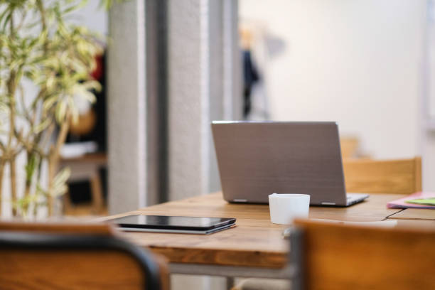 istock Cup of coffee, note PC and tablet PC on the desk 991444348