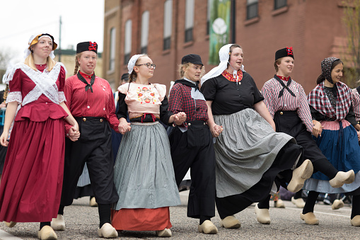 Holland, Michigan, USA - May 12, 2018 A group of young dutch women wearing traditional clothing perform a traditional dance at the Muziek Parade, during the Tulip Time Festival