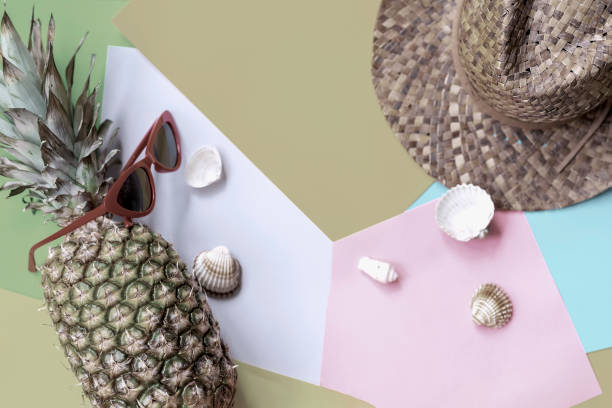 istock Tropical pineapple on pastel colorful background with hat, glasses, seashells, top view. Modern summer concept 991466378