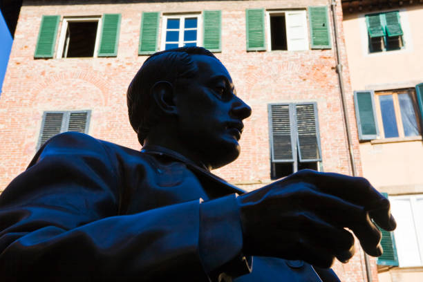 The bronze statue of Giacomo Puccini Lucca, Italy - April 30, 2017: The bronze statue of Giacomo Puccini asserts its presence in front of the Italian composer's birthplace in Lucca, Italy. Work of the sculptor Vito Tongiani giacomo puccini stock pictures, royalty-free photos & images