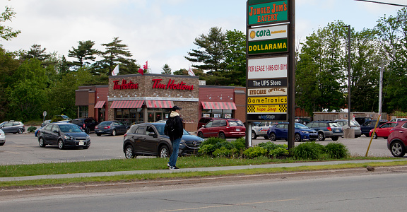 June 3, 2018- Commercial Street, New Minas, Nova Scotia: A busy Tim Hortons franchise on Commercial Street with sign for a plaza including Jungle Jims